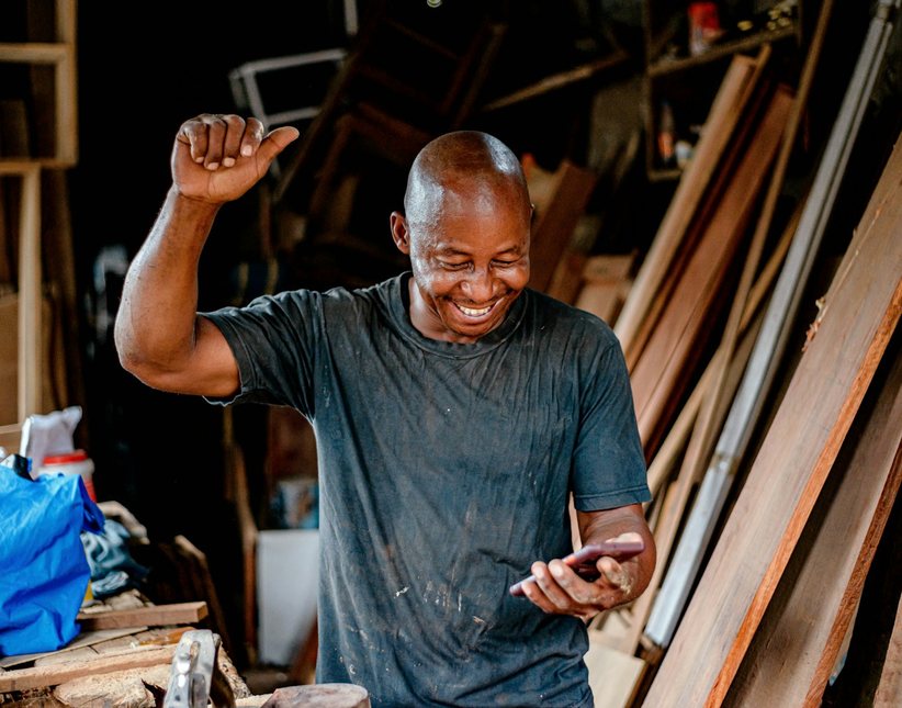 Kenyan seller checking his phone at work